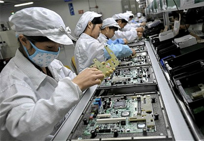 Operários chineses trabalham na linha de produção da Foxconn em Shenzhen, na China (Foto: Getty Images)