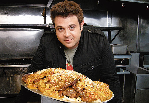 Man vs. food | Travel Channel  O apresentador Adam Richman viaja pelos Estados Unidos em busca de restaurantes que sirvam porções enormes, capazes de desafiar seu apetite. Entre os pratos enfrentados há burritos de 3 quilos (Foto: Divulgação)